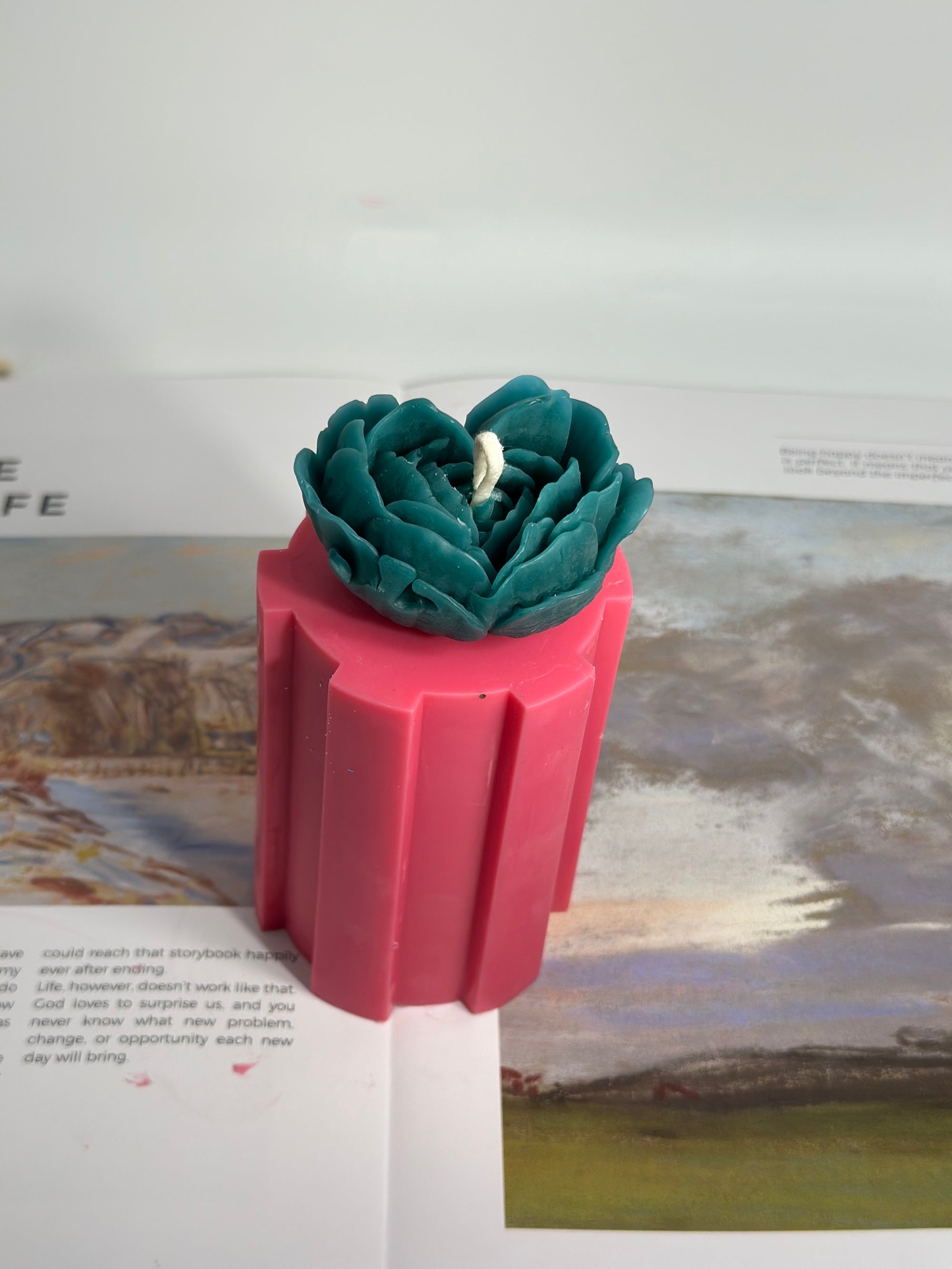 Bougie florale artisanale, base rose intense et fleur turquoise sculptée à la main. Création Cléopâtre Lumière.